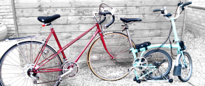 Raleigh Stratos and Brompton bicycles, propped up against the shed